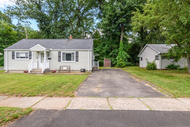 76 Landers Rd, East Hartford, CT 06118 - view of front of home with driveway, a front lawn, roof with shingles, and a chimney