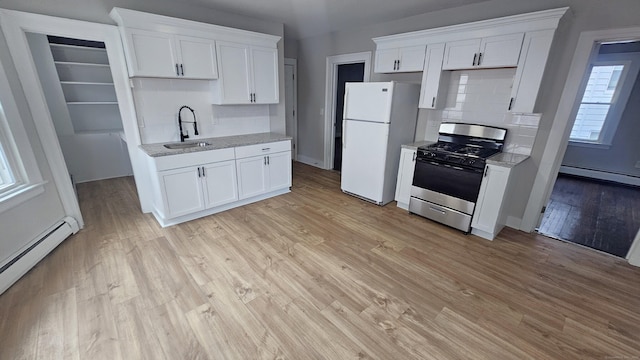 62 Miller St, New Britain, CT 06053 - kitchen with stainless steel range with gas stovetop, freestanding refrigerator, baseboard heating, backsplash, and a baseboard heating unit