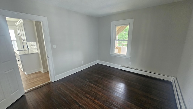 62 Miller St, New Britain, CT 06053 - empty room with a baseboard heating unit and dark wood finished floors