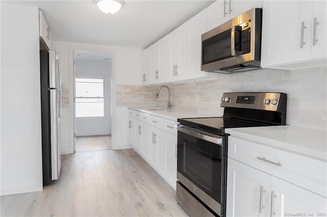 33 William St, Danbury, CT 06810 - kitchen with stainless steel appliances, light countertops, light wood-style floors, and white cabinets
