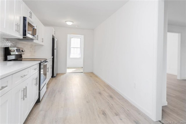 33 William St, Danbury, CT 06810 - kitchen featuring stainless steel appliances, light wood-style floors, light countertops, and decorative backsplash