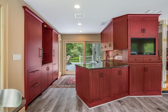 8 Up The Rd, Simsbury, CT 06092 - kitchen featuring light wood-style floors, a peninsula, dark stone counters, recessed lighting, and decorative backsplash