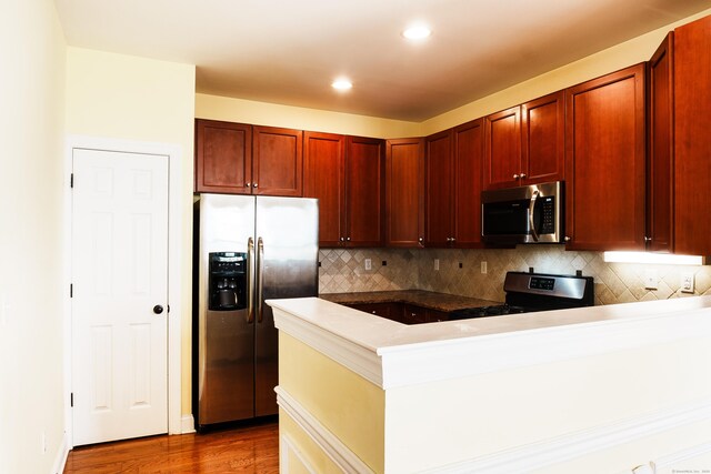14 Last Leaf Cir Unit 14, Windsor, CT 06095 - kitchen with appliances with stainless steel finishes, a peninsula, decorative backsplash, wood finished floors, and dark brown cabinets