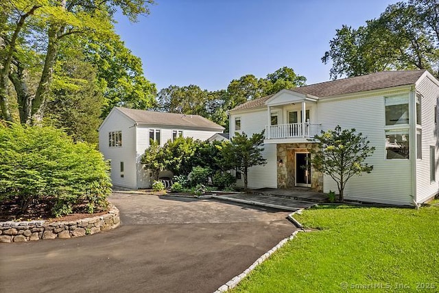 106A Comstock Hill Ave, Norwalk, CT 06850 - view of front facade featuring stone siding, a balcony, driveway, and a front yard