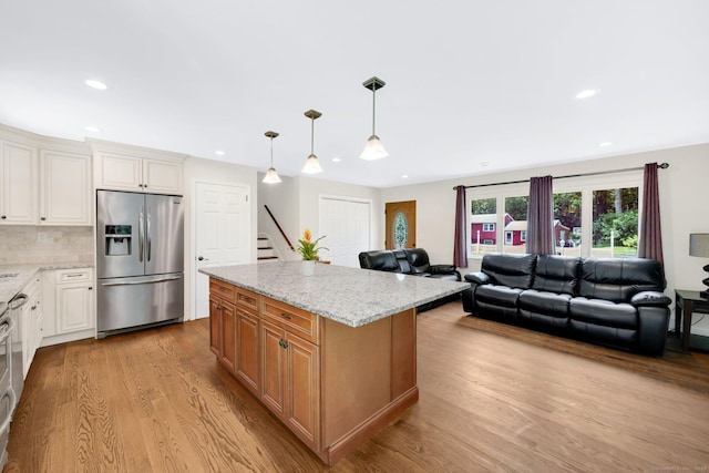 18 Arbor Rd, Monroe, CT 06468 - kitchen featuring stainless steel fridge, light wood-type flooring, light stone counters, recessed lighting, and open floor plan