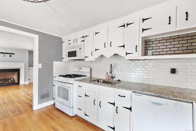 3 Lynette Dr, North Haven, CT 06473 - kitchen featuring white appliances, decorative backsplash, light wood-type flooring, white cabinets, and a fireplace
