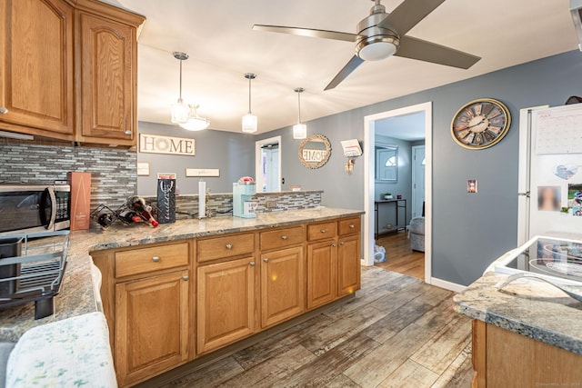 19 Marion St, Hartford, CT 06106 - kitchen featuring stainless steel microwave, a peninsula, backsplash, wood finished floors, and ceiling fan