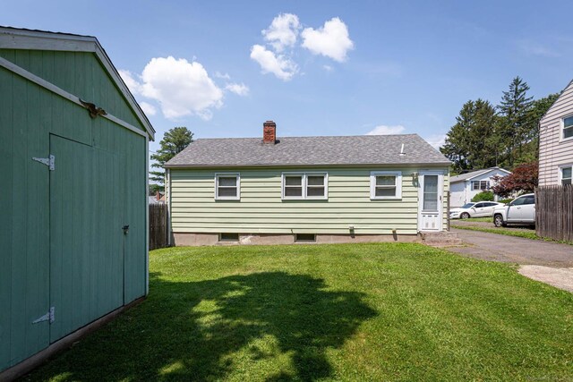 19 Marion St, Hartford, CT 06106 - back of house with a chimney, a lawn, roof with shingles, and an outdoor structure