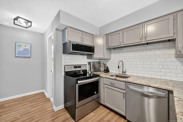182 Shagbark Dr Unit 182, Derby, CT 06418 - kitchen featuring appliances with stainless steel finishes, gray cabinetry, light wood-style floors, decorative backsplash, and a textured ceiling