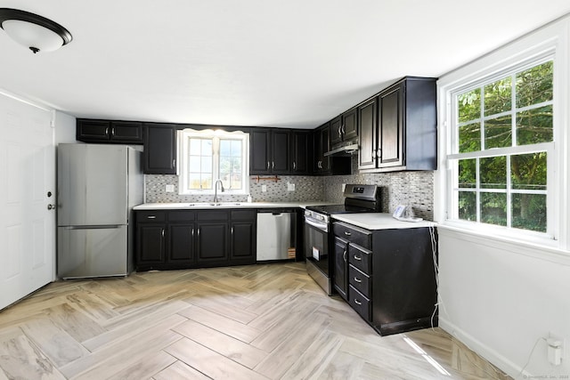 5 Church St Apt R, East Windsor, CT 06016 - kitchen with appliances with stainless steel finishes, under cabinet range hood, dark cabinets, light countertops, and decorative backsplash