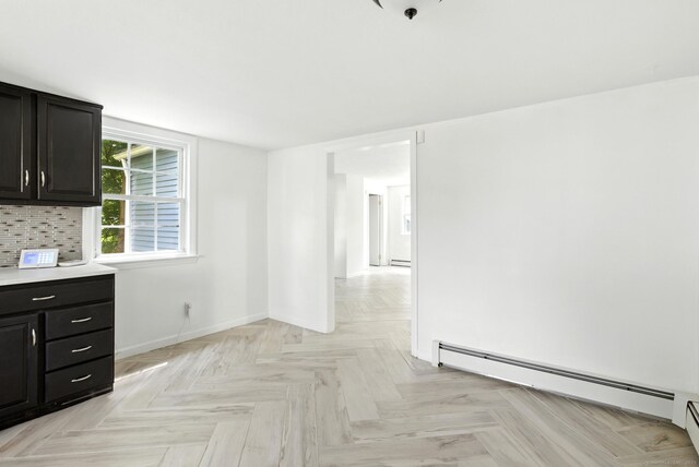 5 Church St Apt R, East Windsor, CT 06016 - kitchen with a baseboard radiator, dark cabinets, baseboard heating, light countertops, and decorative backsplash