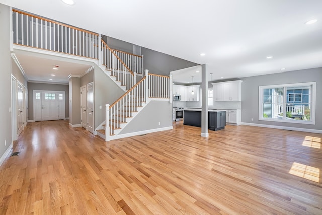 6 Kaatskill Ln, East Lyme, CT 06357 - unfurnished living room with light wood-type flooring, recessed lighting, stairway, and ornamental molding