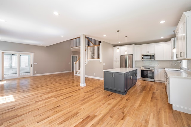 6 Kaatskill Ln, East Lyme, CT 06357 - kitchen with stainless steel appliances, a center island, light countertops, open floor plan, and light wood finished floors