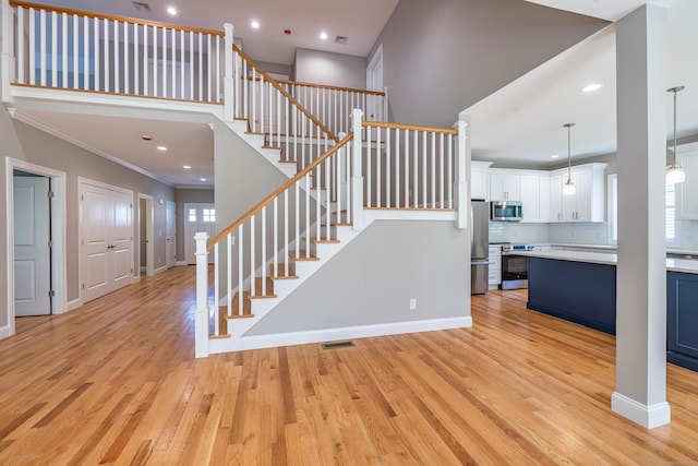 6 Kaatskill Ln, East Lyme, CT 06357 - staircase featuring wood finished floors, ornamental molding, recessed lighting, and a high ceiling