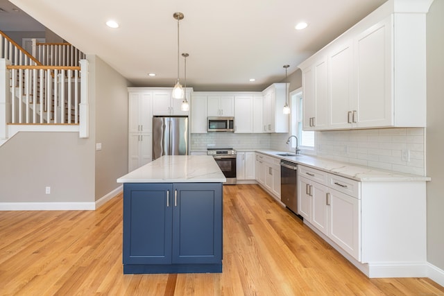 6 Kaatskill Ln, East Lyme, CT 06357 - kitchen with appliances with stainless steel finishes, light wood-type flooring, white cabinets, backsplash, and hanging light fixtures