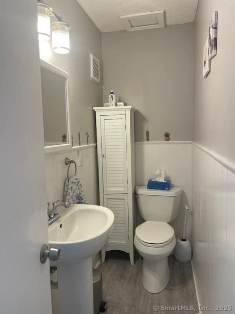 104 N Turnpike Rd Unit B, Wallingford, CT 06492 - half bathroom featuring wood finished floors and a wainscoted wall