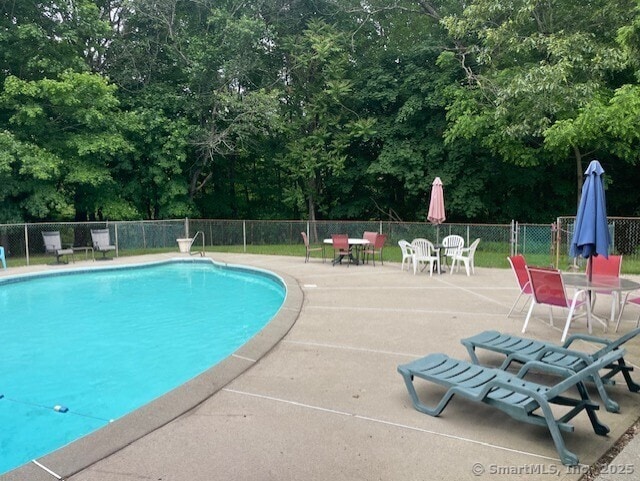 104 N Turnpike Rd Unit B, Wallingford, CT 06492 - view of swimming pool featuring a patio, view of wooded area, and outdoor dining space