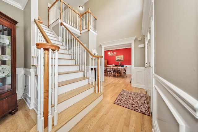 118 Cobblestone Dr, Southington, CT 06479 - foyer entrance featuring a chandelier, a towering ceiling, a wainscoted wall, stairs, and wood finished floors