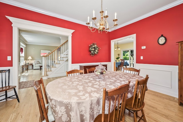 118 Cobblestone Dr, Southington, CT 06479 - dining room with light wood-type flooring, a chandelier, stairs, a wainscoted wall, and ornamental molding