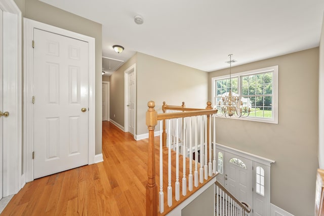 118 Cobblestone Dr, Southington, CT 06479 - corridor featuring an upstairs landing, attic access, light wood-style floors, and a chandelier