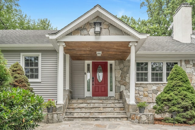 46 Bowman Dr, Greenwich, CT 06831 - view of exterior entry with stone siding, a chimney, and roof with shingles