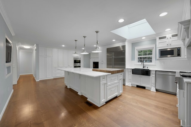 46 Bowman Dr, Greenwich, CT 06831 - kitchen with built in appliances, a skylight, ornamental molding, decorative backsplash, and a center island