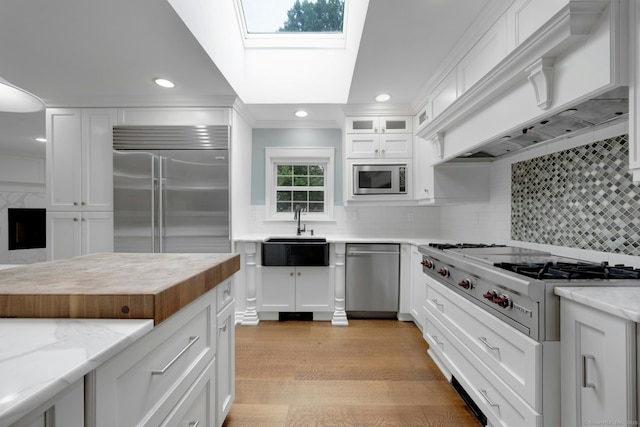 46 Bowman Dr, Greenwich, CT 06831 - kitchen featuring built in appliances, white cabinets, recessed lighting, butcher block counters, and a skylight