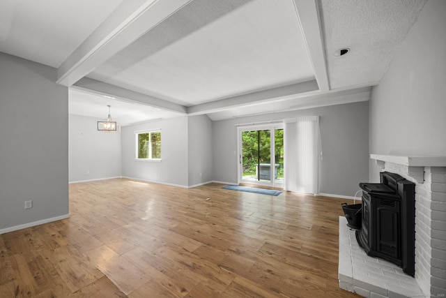 737 Heritage Vlg Unit A, Southbury, CT 06488 - unfurnished living room with a wood stove, beam ceiling, and light wood-style floors