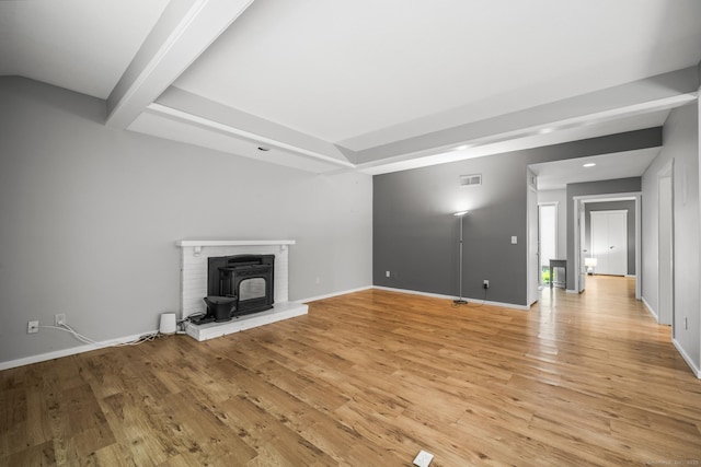 737 Heritage Vlg Unit A, Southbury, CT 06488 - unfurnished living room with light wood finished floors, recessed lighting, beamed ceiling, and a wood stove
