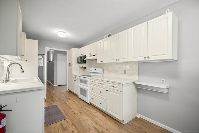 737 Heritage Vlg Unit A, Southbury, CT 06488 - kitchen with white electric range oven, under cabinet range hood, stainless steel microwave, decorative backsplash, and white cabinetry