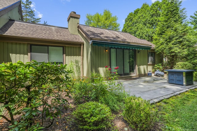737 Heritage Vlg Unit A, Southbury, CT 06488 - rear view of property featuring a chimney, a shingled roof, and a patio