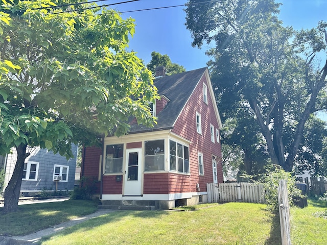 23 Carely Ave, Griswold, CT 06351 - view of front of home featuring roof with shingles, a sunroom, a chimney, and entry steps