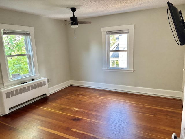 23 Carely Ave, Griswold, CT 06351 - empty room featuring radiator heating unit, dark wood finished floors, healthy amount of natural light, and ceiling fan
