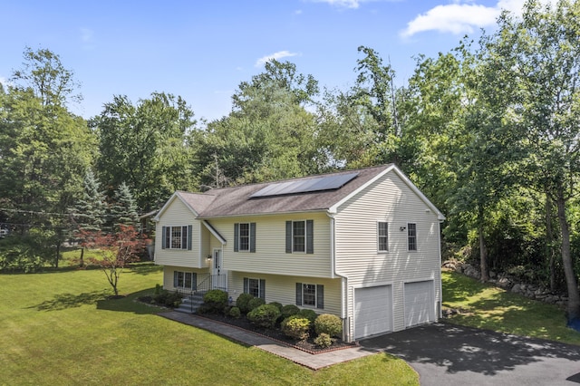 24 Ken Oaks Dr, Danbury, CT 06810 - view of front of home with an attached garage, asphalt driveway, solar panels, a front yard, and view of scattered trees