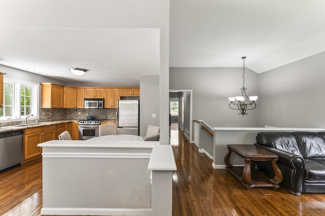 24 Ken Oaks Dr, Danbury, CT 06810 - kitchen featuring appliances with stainless steel finishes, dark wood finished floors, tasteful backsplash, a kitchen island, and a chandelier