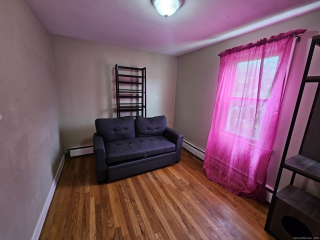 209 Maple St, East Hartford, CT 06118 - living area with baseboard heating and wood finished floors