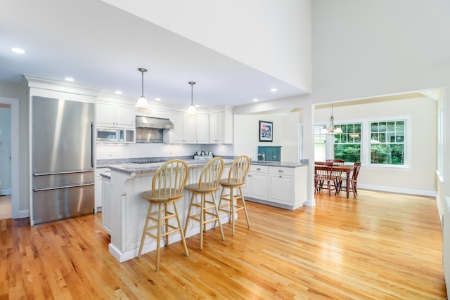 35 Vista Rd, Wilton, CT 06897 - kitchen with high end refrigerator, exhaust hood, built in microwave, white cabinetry, and recessed lighting