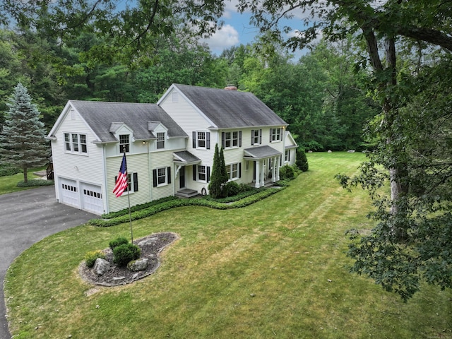 35 Vista Rd, Wilton, CT 06897 - view of front of house featuring asphalt driveway, a garage, a chimney, and a front lawn