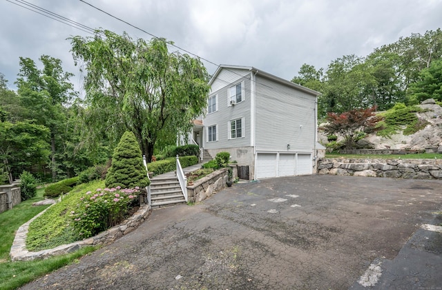 30 Partridge Rd, Stamford, CT 06903 - view of side of property with stairway, an attached garage, and driveway