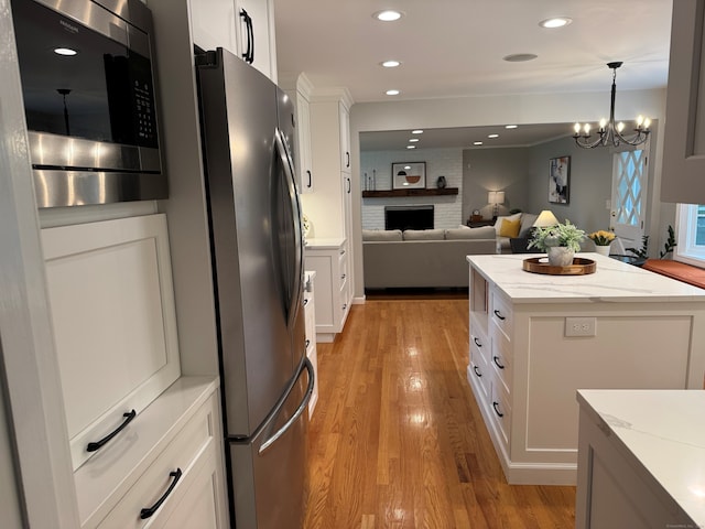 475 Riverside Dr, Cheshire, CT 06410 - kitchen featuring stainless steel appliances, light wood-style floors, white cabinetry, light stone countertops, and recessed lighting
