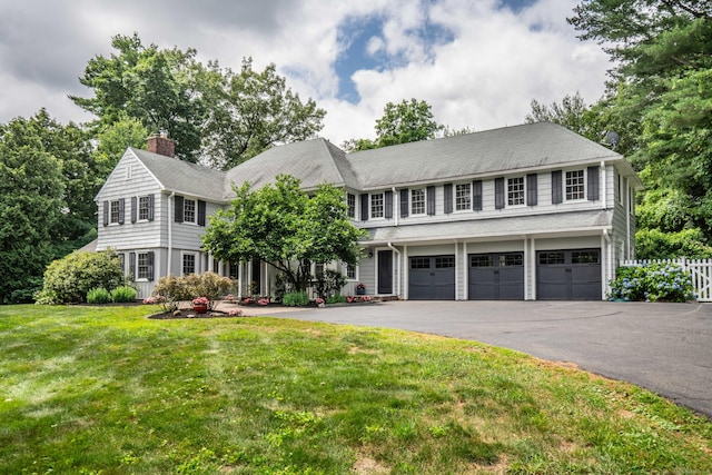 35 Walker Ln, West Hartford, CT 06117 - view of front facade with a garage, asphalt driveway, and a chimney