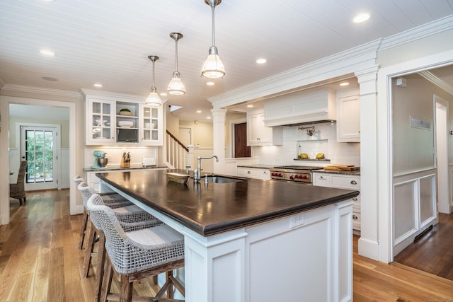 35 Walker Ln, West Hartford, CT 06117 - kitchen featuring dark countertops, crown molding, ornate columns, white cabinets, and glass insert cabinets