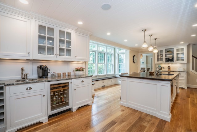 35 Walker Ln, West Hartford, CT 06117 - kitchen with beverage cooler, white cabinetry, light wood-style floors, glass insert cabinets, and recessed lighting
