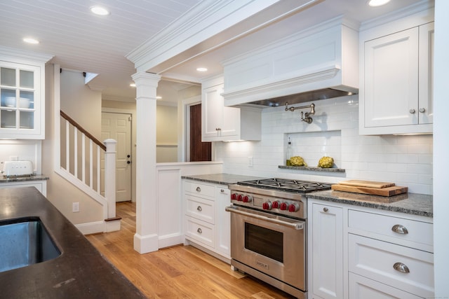 35 Walker Ln, West Hartford, CT 06117 - kitchen with premium stove, white cabinetry, decorative backsplash, light wood-type flooring, and recessed lighting