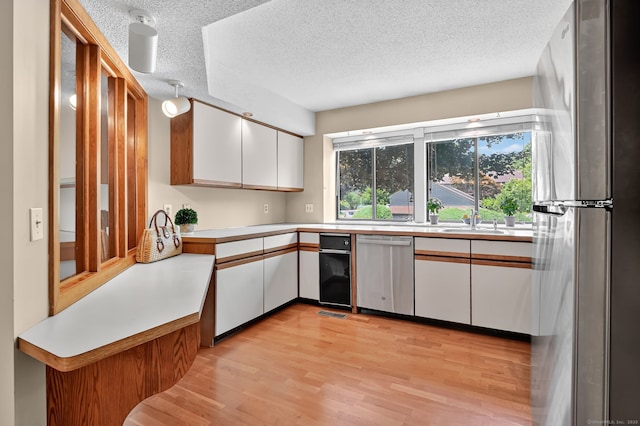 55 Wickhams Fancy Unit 55, Canton, CT 06019 - kitchen featuring appliances with stainless steel finishes, white cabinetry, light countertops, light wood finished floors, and a textured ceiling