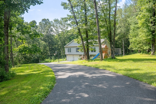 81 Lillis Rd, New Milford, CT 06776 - view of front of house with an attached garage, a trampoline, asphalt driveway, and a front yard