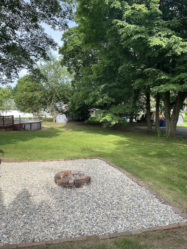56 N Maple St, Enfield, CT 06082 - view of green lawn with a fire pit and a storage unit