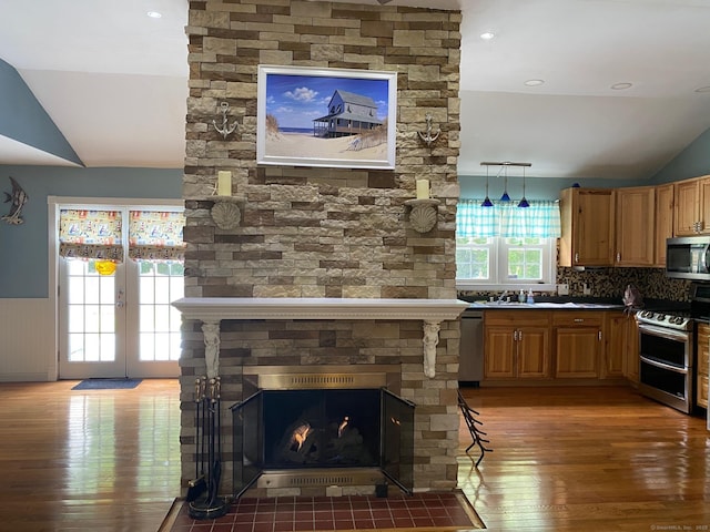 18 Bch Park Rd, Clinton, CT 06413 - kitchen featuring stainless steel appliances, vaulted ceiling, light wood-type flooring, wainscoting, and decorative backsplash