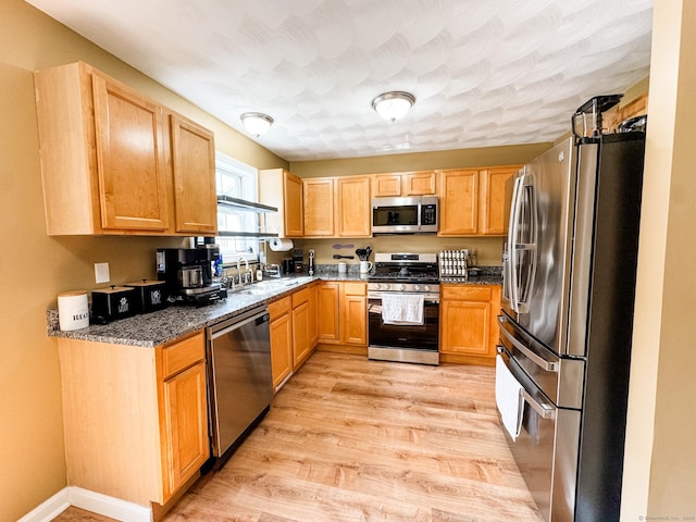 60 Sachem Dr Unit 60, Plainfield, CT 06374 - kitchen with stainless steel appliances, light wood-style floors, dark stone countertops, and light brown cabinets