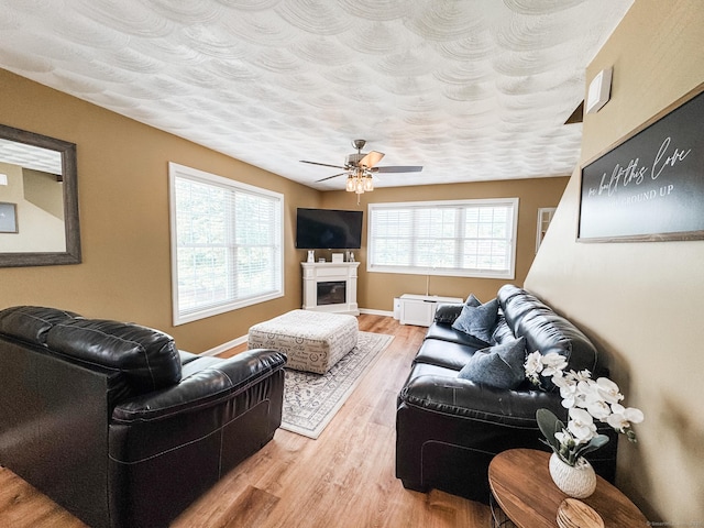 60 Sachem Dr Unit 60, Plainfield, CT 06374 - living area featuring wood finished floors, a ceiling fan, a glass covered fireplace, and a textured ceiling